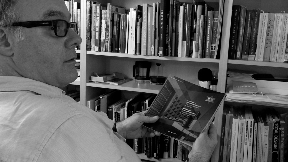 Professor Marco Polo holding a copy of Architecture and National Identity: The Centennial Projects 50 Years On
